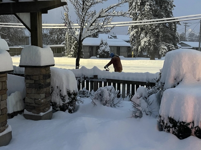 a man operating a snow plow in the distance