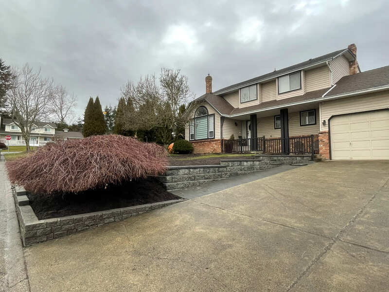 stack stone wall coming off the driveway extension following the drive way down to the road and then corning then following a line along the street curb
