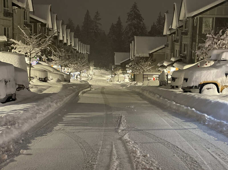 a ver snowy strata street that has just been plowed but is already starting to accumulate snow