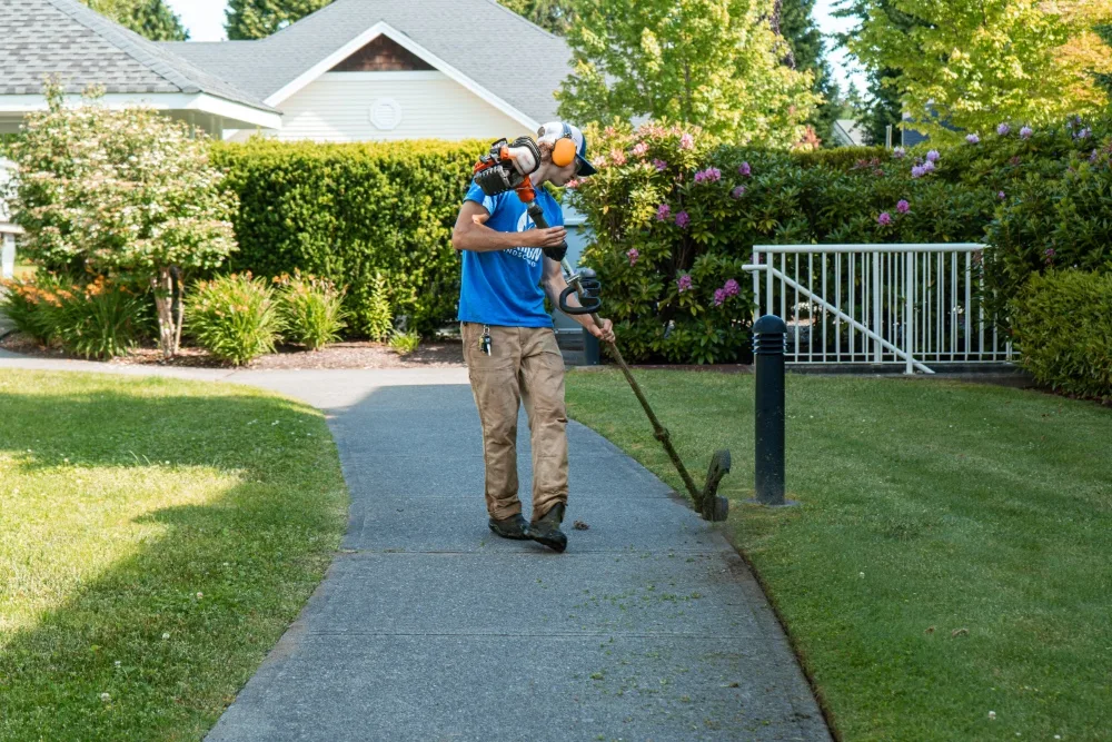 atkinson landscaping staff memeber line trimming a strata property walkway